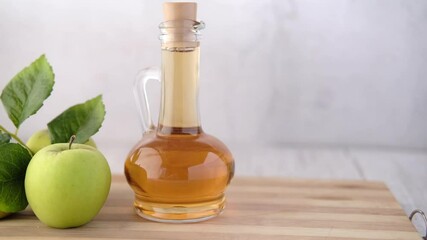 Wall Mural - apple vinegar in glass bottle with fresh green apple on table 