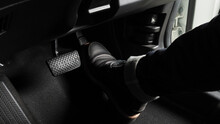 Close Up The Foot Pressing Foot Pedal Of A Car To Drive. Accelerator And Brake Pedal In A Car. Driver Driving The Car By Pushing Accelerator And Break Pedals Of The Car. Inside Vehicle. Control Pedal.