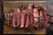 Sliced grilled meat steak Rib eye medium rare, on wooden serving board, on old dark  wooden table background, top view flat lay