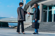 © qunica.com - Businessman and businesswoman greeting one another by shaking hands