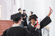 © LIGHTFIELD STUDIOS - Cheerful african american graduate holding diploma near friend on blurred foreground