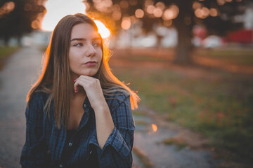 Canvas Print - Closeup shot of a beautiful Caucasian woman with blonde hairs on the sunset background