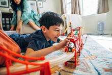 Boy Playing With Toy Train In Living Room