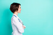 © deagreez - Profile side photo of young woman happy smile folded hands look empty space doctor isolated over teal color background
