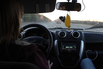 Girl is driving on the track. photo inside the car