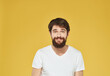 © SHOTPRIME STUDIO - Portrait of a man bushy beard mustache white t-shirt yellow background cropped view