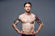© SHOTPRIME STUDIO - sporty man tattoos on his arms naked torso bodybuilder gray background