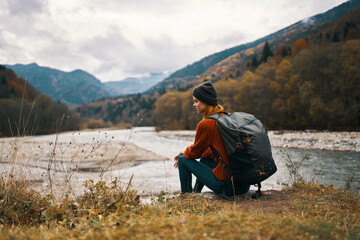 woman with backpack by the river mountain landscape autumn dry grass model