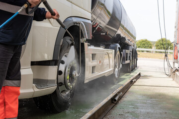 Tank truck driver cleaning the exterior of the vehicle.