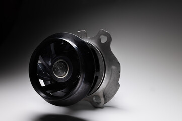 Wall Mural - Close-up of an automobile engine liquid cooling pump. new part on gray gradient background