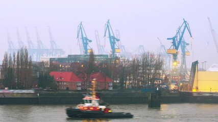 Wall Mural - Hamburg, Germany. Port of Hamburg on the river Elbe in Germany in the morning. Huge industrial cranes with the cloudy misty sky, panning video
