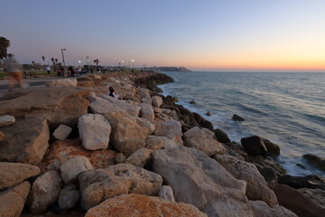 sunset on the sea, rocky stony shore in Tel Aviv, Israel