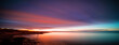 Long exposure panorama of the sunset sky at the sea. Orange turquoise sky during sea sunsets