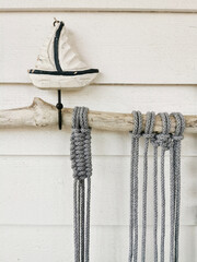 Crochet from grey cotton yarn wall hanging with a boat sculpture on it