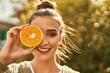 Beautiful brunette woman smiling happy with half orange over eye
