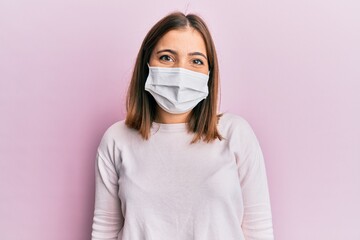 Poster - Young beautiful woman wearing medical mask with a happy and cool smile on face. lucky person.