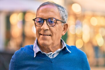 Wall Mural - senior grey-haired man smiling happy standing at the city.