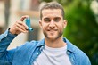 © Krakenimages.com - Young caucasian asthmatic man smiling happy holding inhaler at the park.