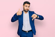 © Krakenimages.com - Young hispanic man wearing business jacket doing thumbs up and down, disagreement and agreement expression. crazy conflict