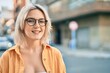 © Krakenimages.com - Young blonde girl smiling happy wearing glasses at the city.