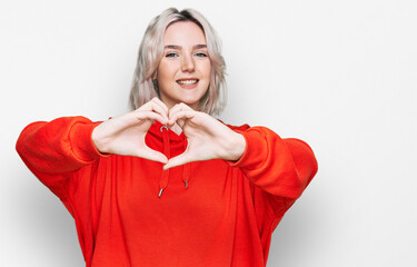 Poster - Young blonde girl wearing casual clothes smiling in love doing heart symbol shape with hands. romantic concept.