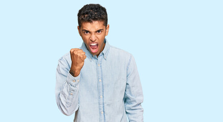 Sticker - Young handsome african american man wearing casual clothes angry and mad raising fist frustrated and furious while shouting with anger. rage and aggressive concept.