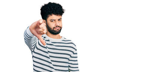 Sticker - Young arab man with beard wearing casual striped sweater looking unhappy and angry showing rejection and negative with thumbs down gesture. bad expression.