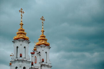 The golden domes of the white church against the blue sky. Religion. The Orthodox Church. Christian holiday.