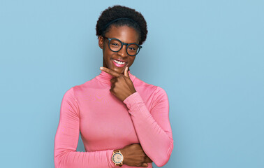 Poster - Young african american girl wearing casual clothes and glasses looking confident at the camera smiling with crossed arms and hand raised on chin. thinking positive.