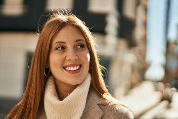 Young redhead girl smiling happy standing at the city.