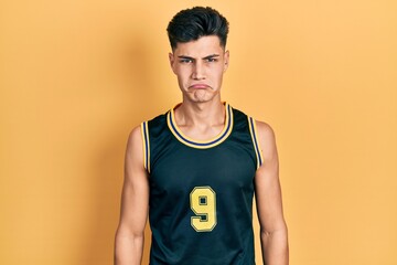 Canvas Print - Young hispanic man wearing basketball uniform depressed and worry for distress, crying angry and afraid. sad expression.