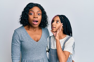 Sticker - Beautiful african american mother and daughter wearing casual clothes and hugging hand on mouth telling secret rumor, whispering malicious talk conversation