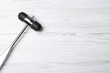 © New Africa - Reflex hammer on white wooden background, top view with space for text. Nervous system diagnostic