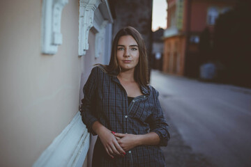 Poster - Young Caucasian woman leaning on the wall in the street