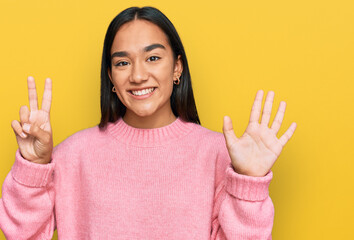 Wall Mural - Young asian woman wearing casual winter sweater showing and pointing up with fingers number seven while smiling confident and happy.