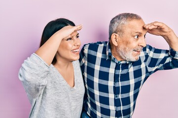 Sticker - Hispanic father and daughter wearing casual clothes very happy and smiling looking far away with hand over head. searching concept.