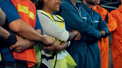 Skillful worker stand together showing teamwork in the factory . Industrial people and manufacturing labor concept .