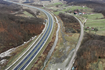 Wall Mural - Aerial view of traffic roads amid agricultural fields and forests with residential buildings