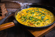 Rustic omelet with potatoes in a cast-iron pan cooked in the oven.