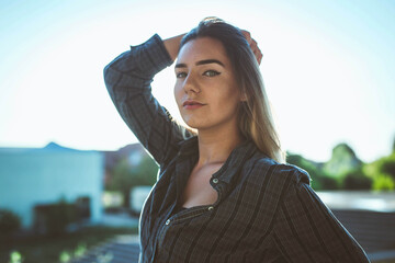 Wall Mural - Beautiful blonde Caucasian woman wearing flannel with hand on her hair