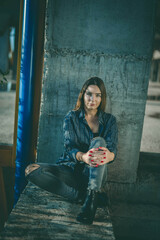 Sticker - Beautiful blonde Caucasian woman wearing flannel posing in an abandoned building