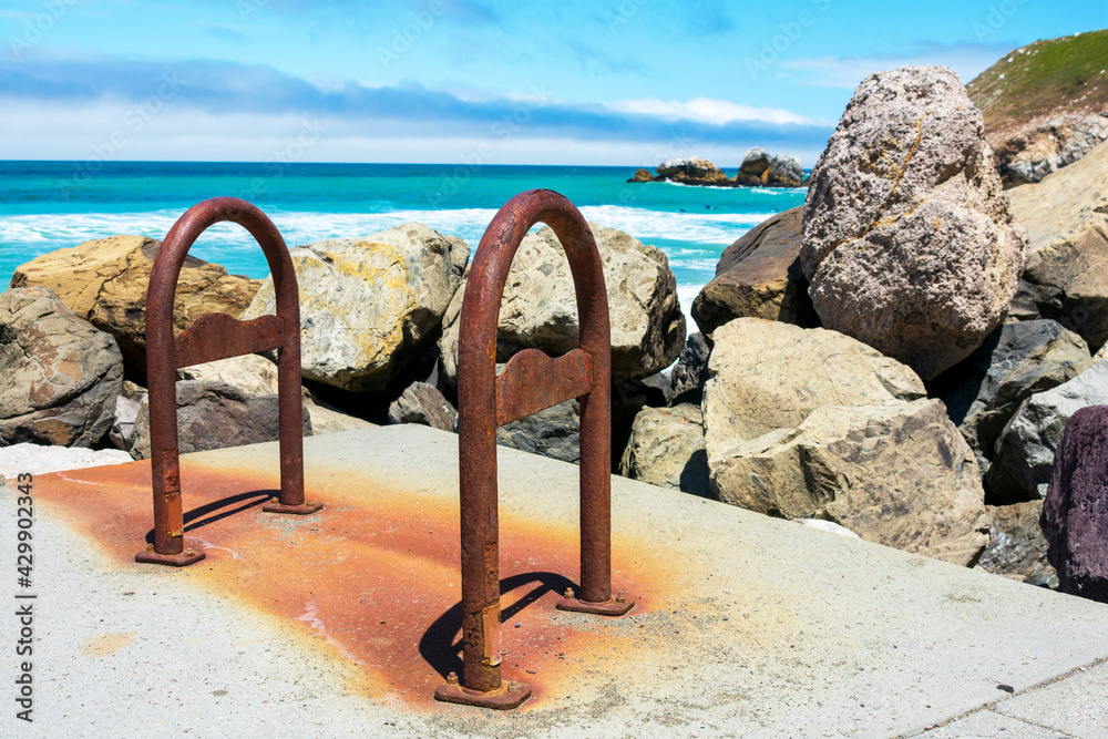 Rusty Bike Racks Rusty and weathered empty bike racks on the ocean coast next to large ...