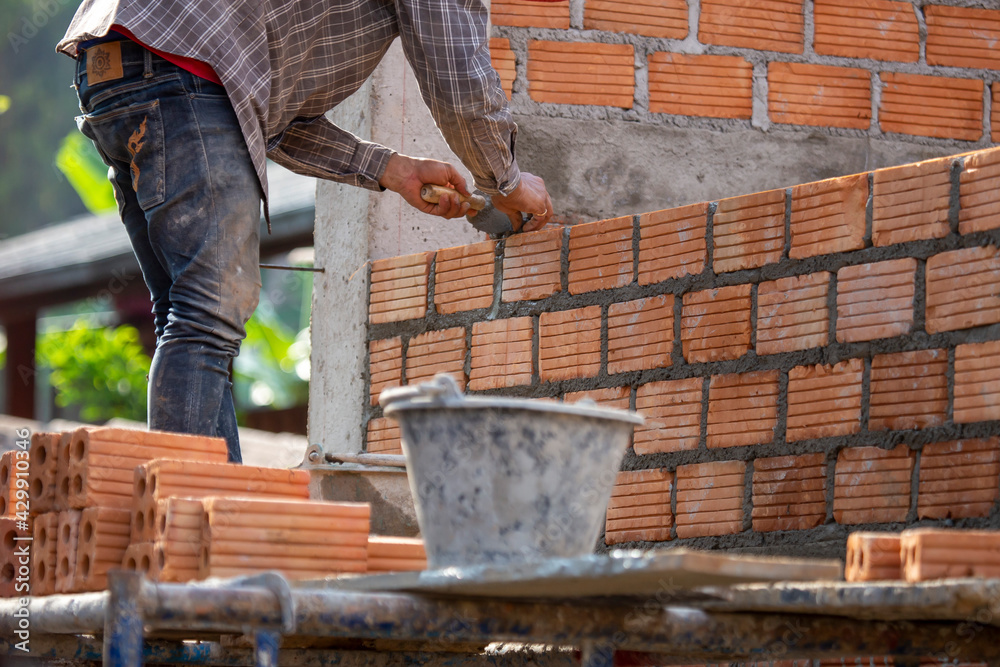 Red bricks and mason are building bricks to build the walls of the ...
