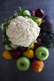 Fototapeta Kuchnia - Colorful vegetables and fruits on gray textured background. Top view photo of cauliflower, apples, peach, avocado, plums. Eating fresh concept. 