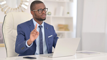 Serious African Businessman with Laptop saying No by Finger Sign 