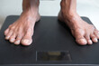 © Towfiqu Barbhuiya  - senior women's feet on weight scale close up.