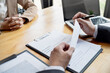 © mojo_cp - Examiner reading a resume during job interview at office