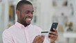© stockbakers - Portrait of African Man Doing Online Payment on Smartphone