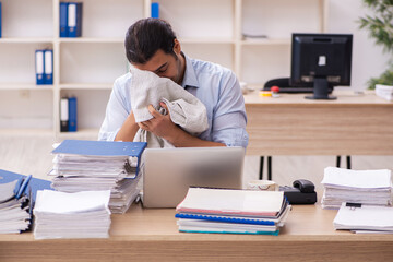 Wall Mural - Young male employee sweating at workplace