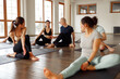 © Ivan - Teacher guides student in yoga class. Young sporty people practicing yoga in modern sport club